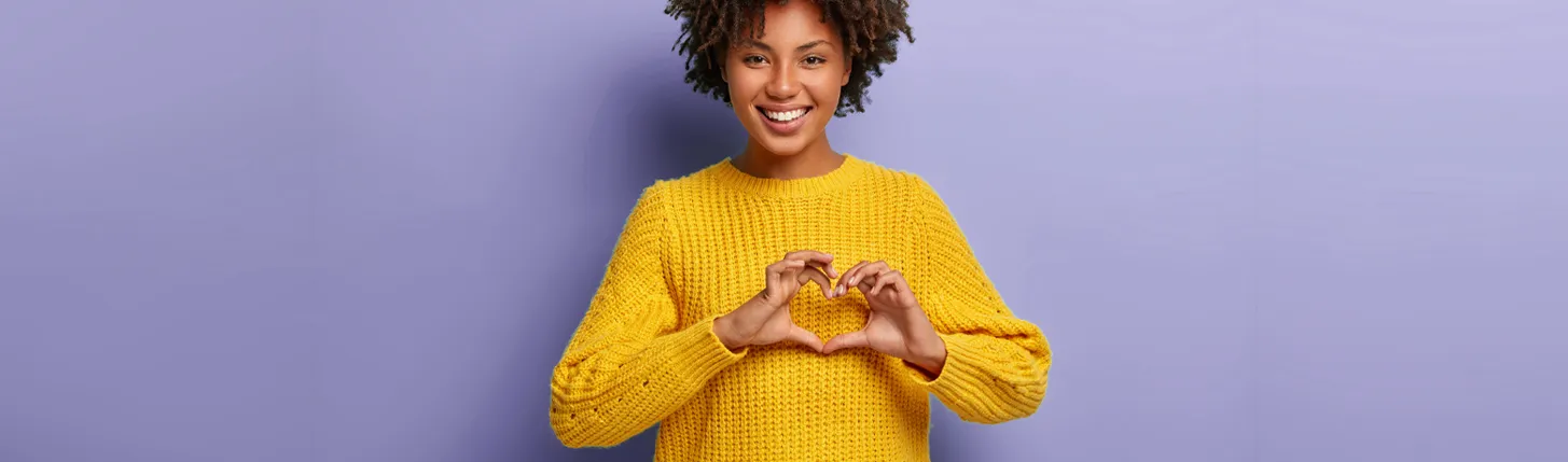 A woman forming a heart shape with her hands.