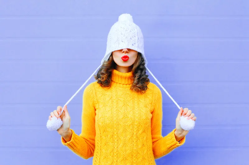 lady from a a winter sweater and beanie with two side strings