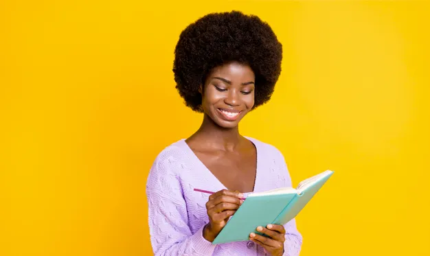 a women writing something on a notebook from Ignition Marketing