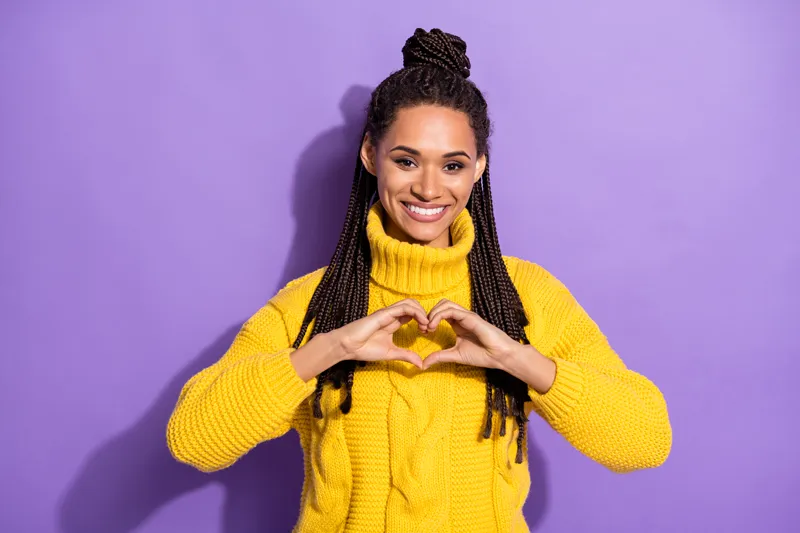 a woman making a heart object with her hands