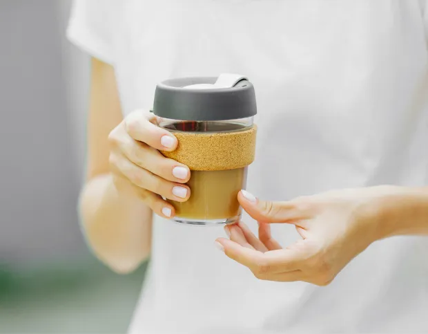 branded glass cup holding coffee