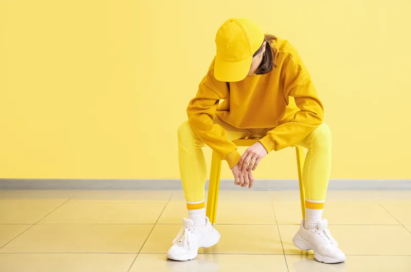 lady sitting on a chair with branded cap and gym clothers
