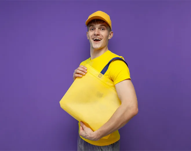 a man smiling holding a branded tote bag from Ignition Marketing