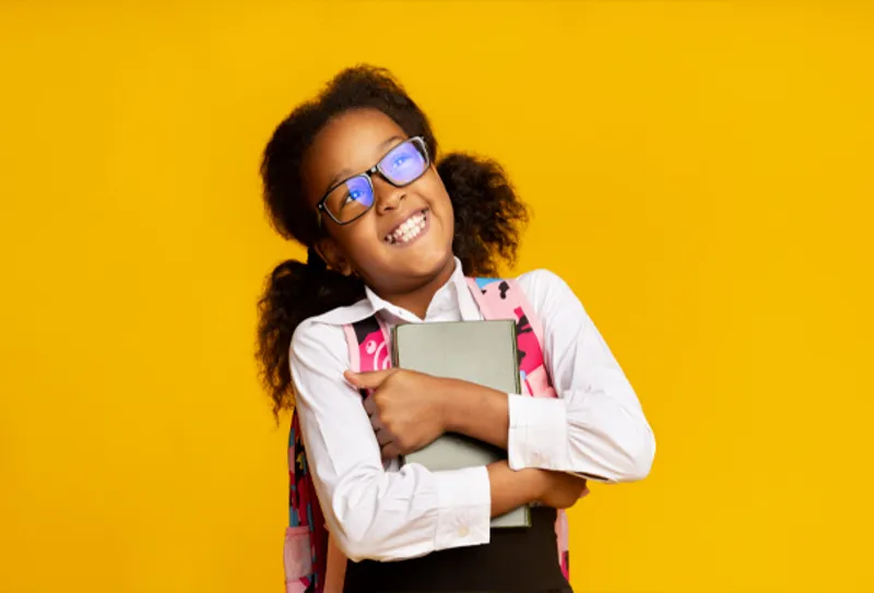 a young girl holding branded notebook and stationery