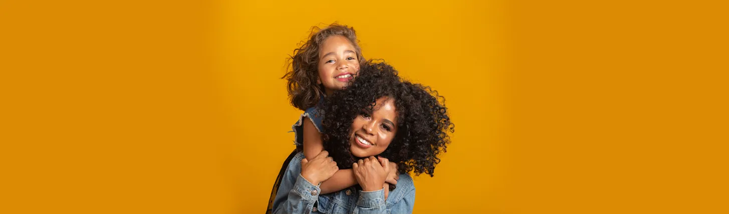 a mother and daughter embracing posing for a picture hero image desktop