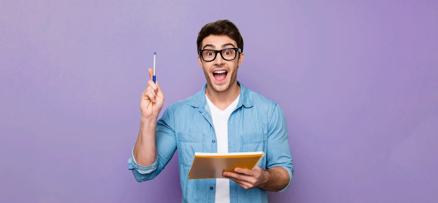a man in excitement holding up a pen and branded notebook