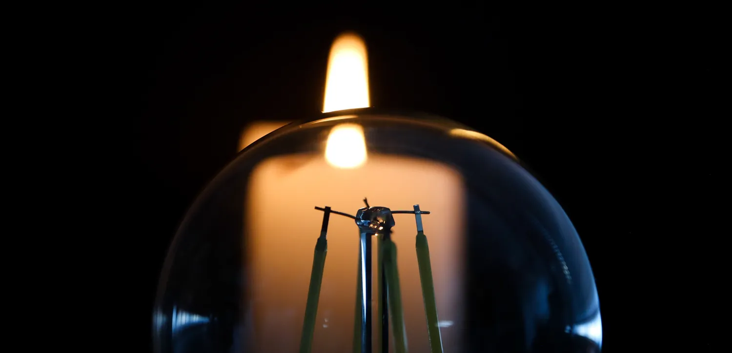 a light bulb with a flame behind the light bulb