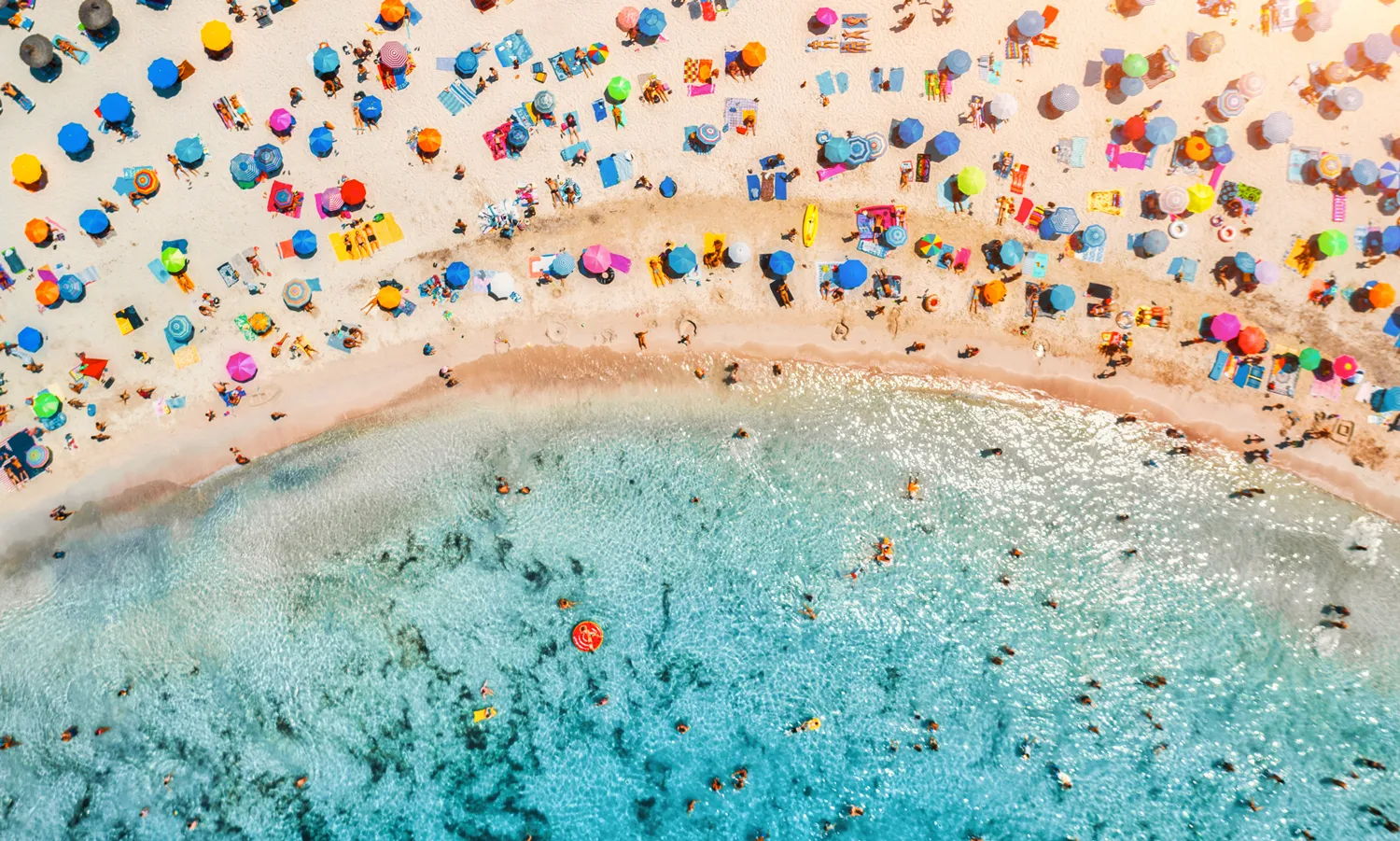 Aerial crowd at the beach - under branded beach umbrellas