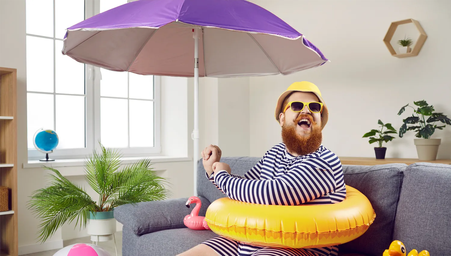 a man sitting indoors with a branded beach umbrella
