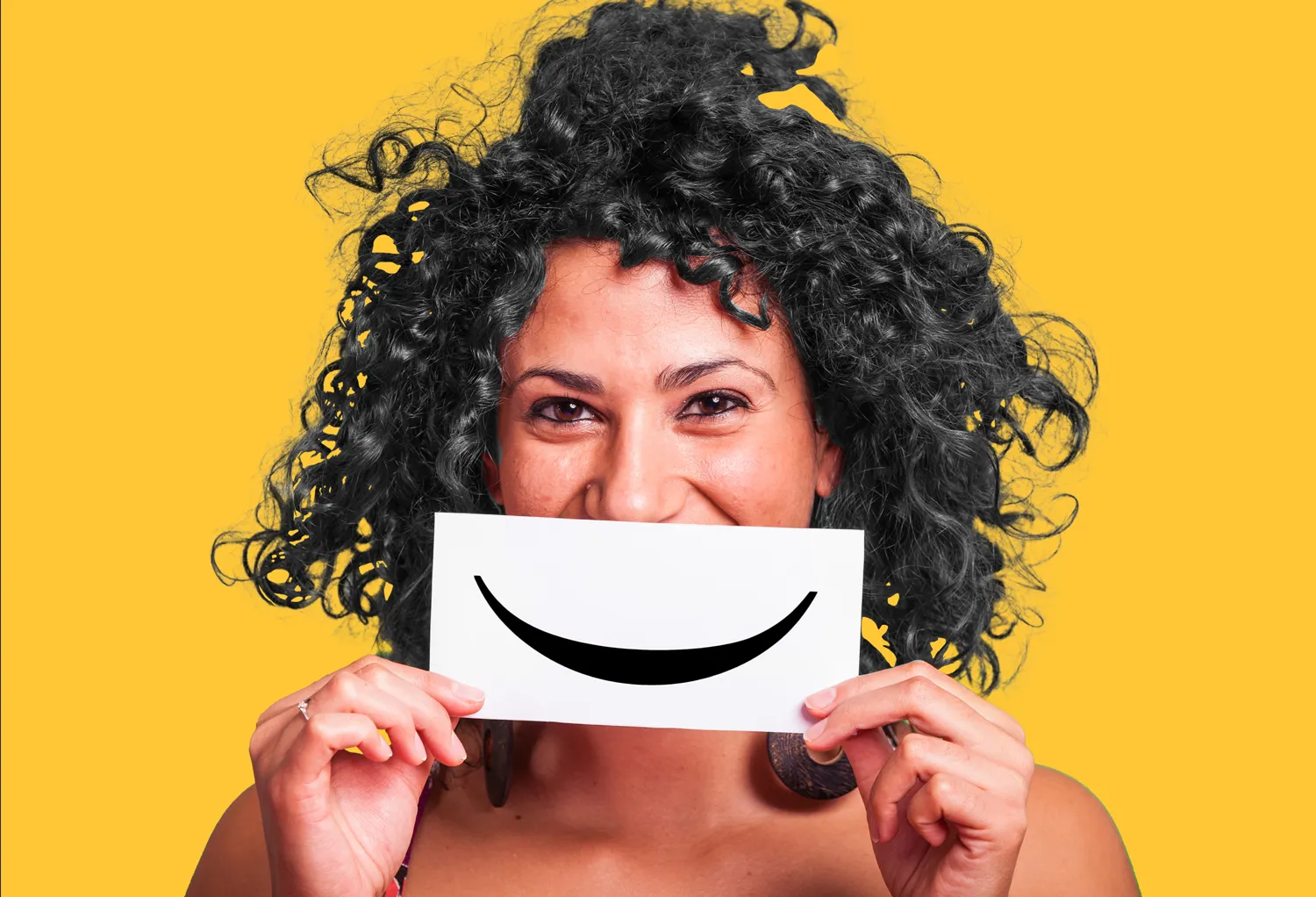 a woman holding up a smiley face card
